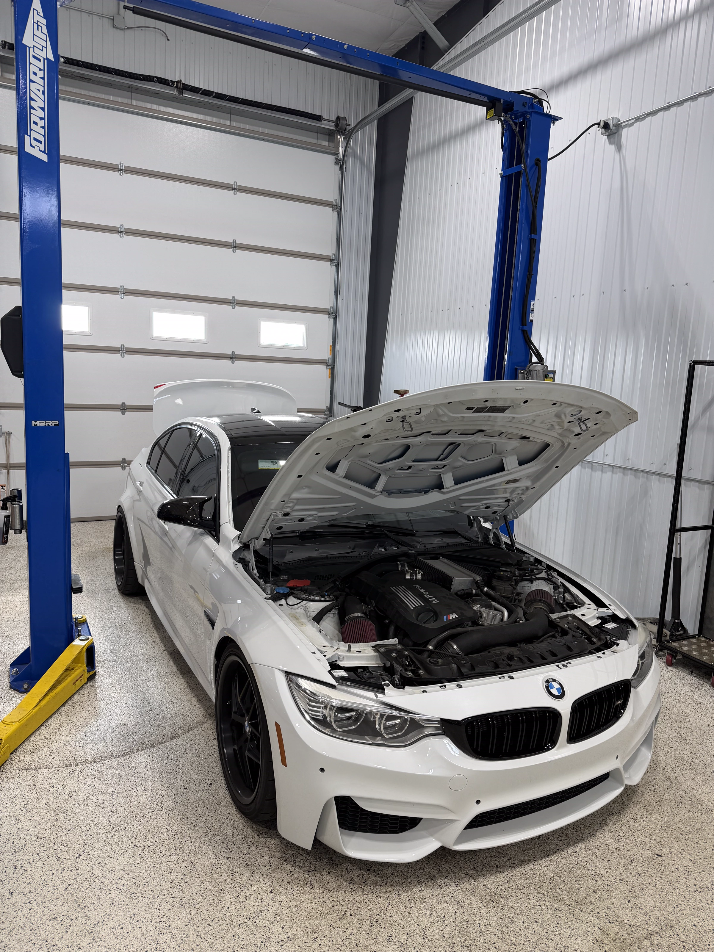White BMW M3 with the hood open for engine work at The Upgrade Shop