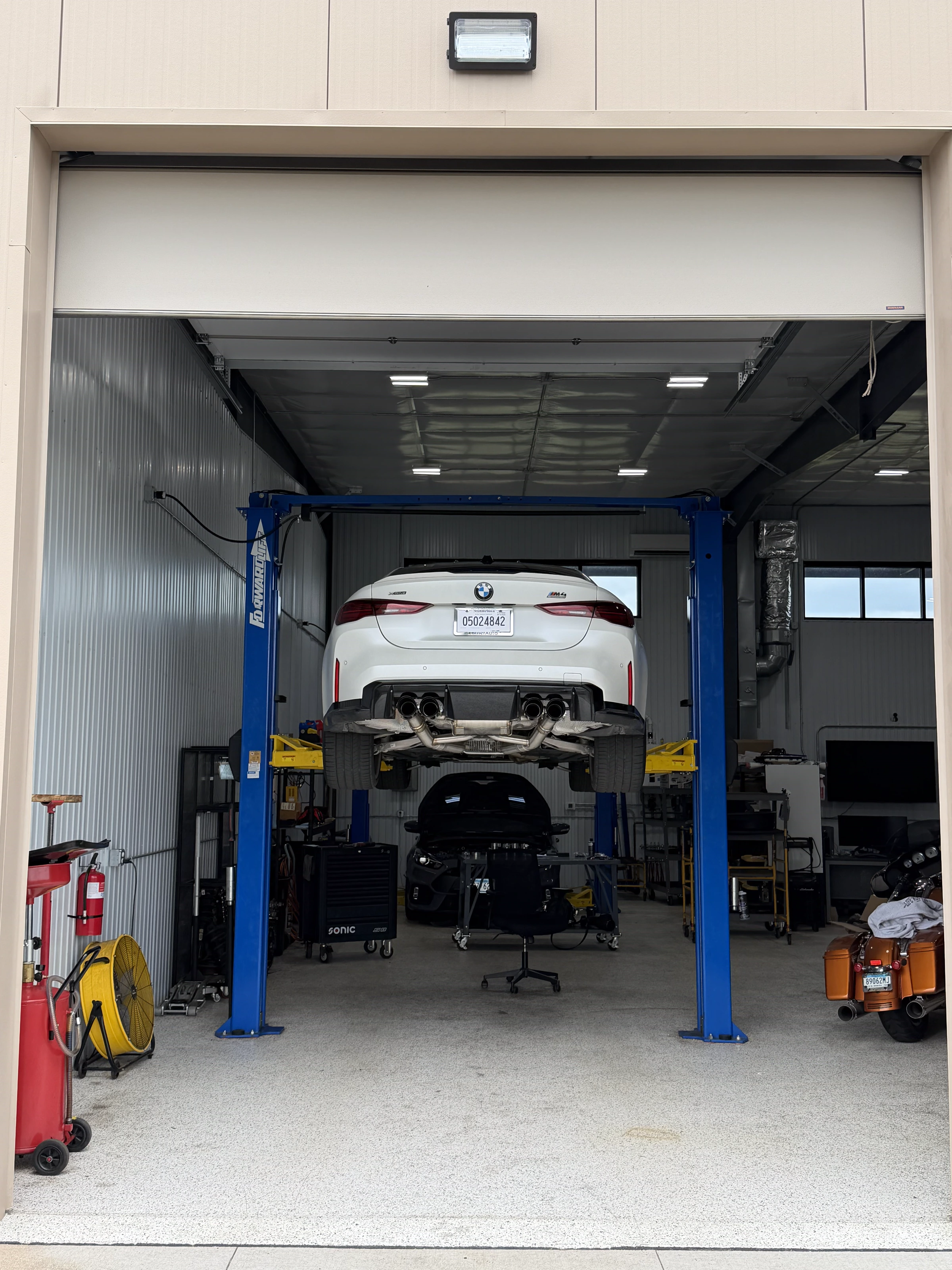 White BMW M4 on the lift at The Upgrade Shop, Unit 123